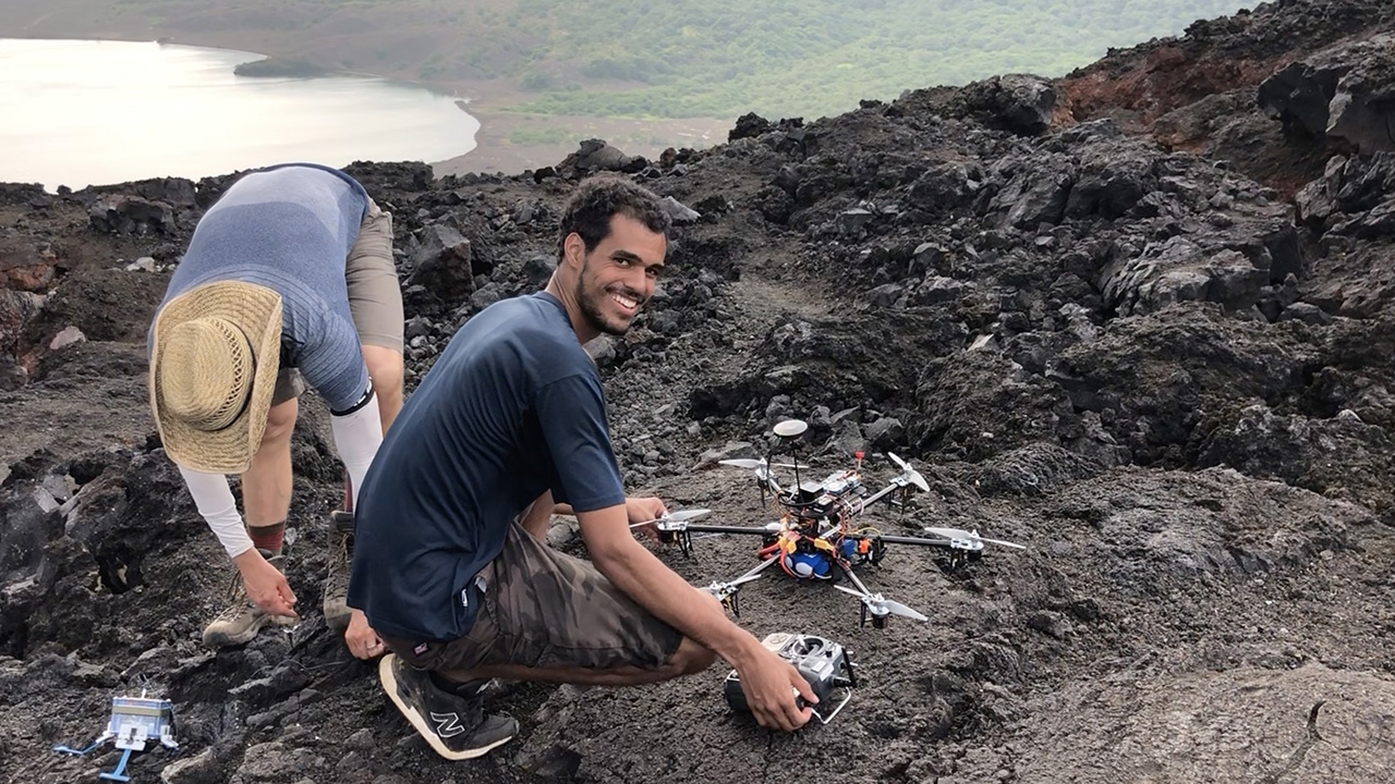 students working with drones near a volcano