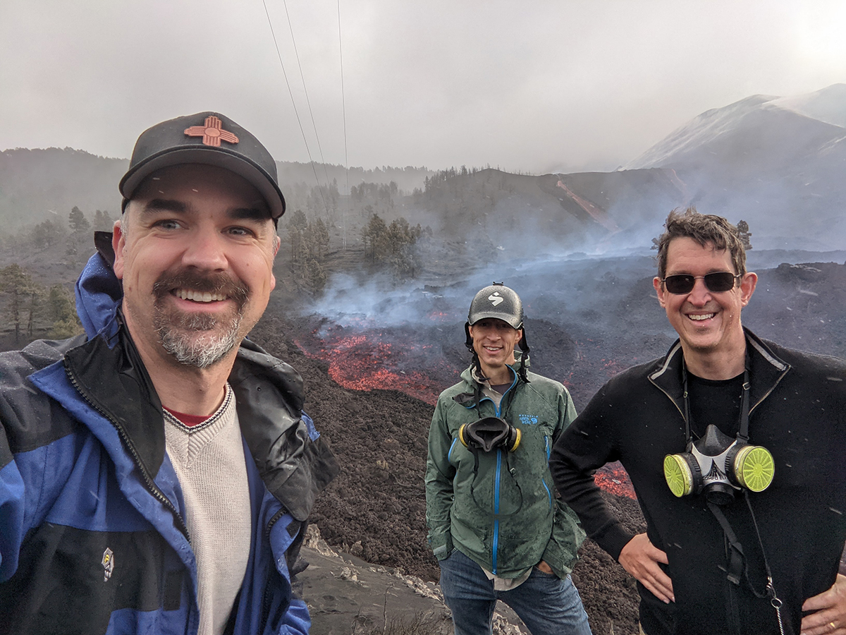 photo: 3 researchers standing in front of volcano